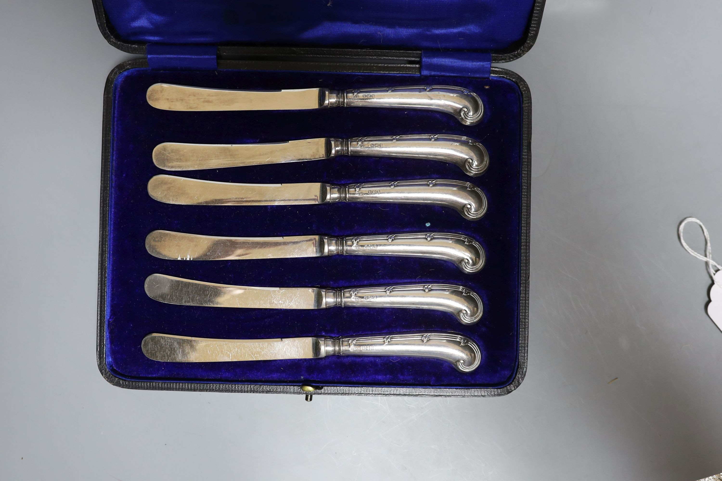 A cased set of silver handled pistol knives and a cased set of mother-of-pearl fruit knives and forks